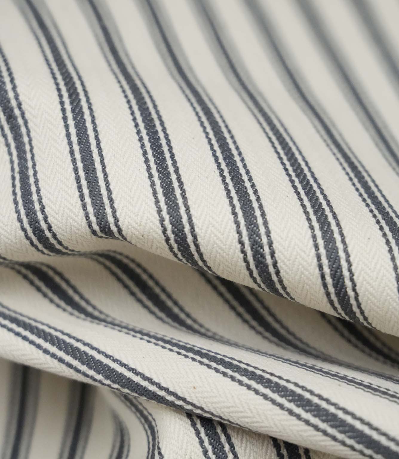 Close-up detail of grey ticking stripe fabric showing the fine woven texture and elegant grey stripe pattern.
