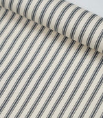 Rolled grey ticking stripe fabric highlighting the classic striped design and subtle woven herringbone texture.