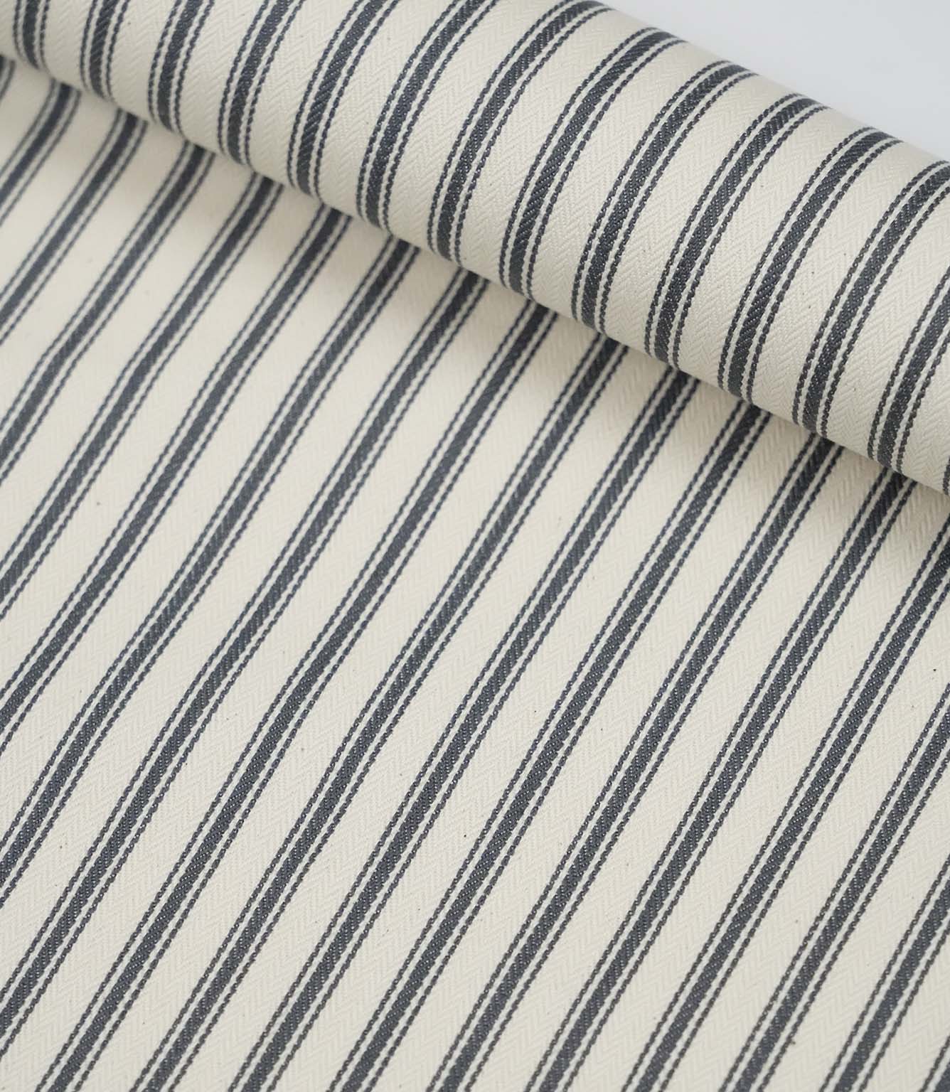 Rolled grey ticking stripe fabric highlighting the classic striped design and subtle woven herringbone texture.