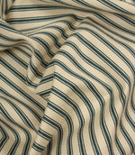 Draped ivory and indigo striped fabric with flowing folds, showing the durable woven texture and timeless upholstery-inspired design.