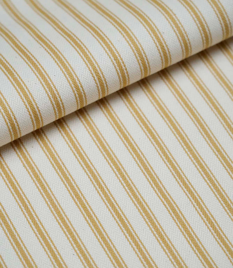 Folded ochre ticking stripe fabric showcasing the timeless striped pattern and premium woven herringbone finish.
