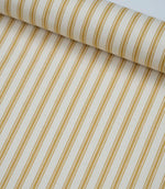 Rolled ochre ticking stripe fabric highlighting the classic striped design and subtle woven herringbone texture.