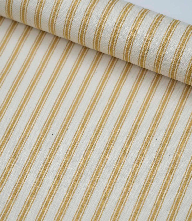 Rolled ochre ticking stripe fabric highlighting the classic striped design and subtle woven herringbone texture.