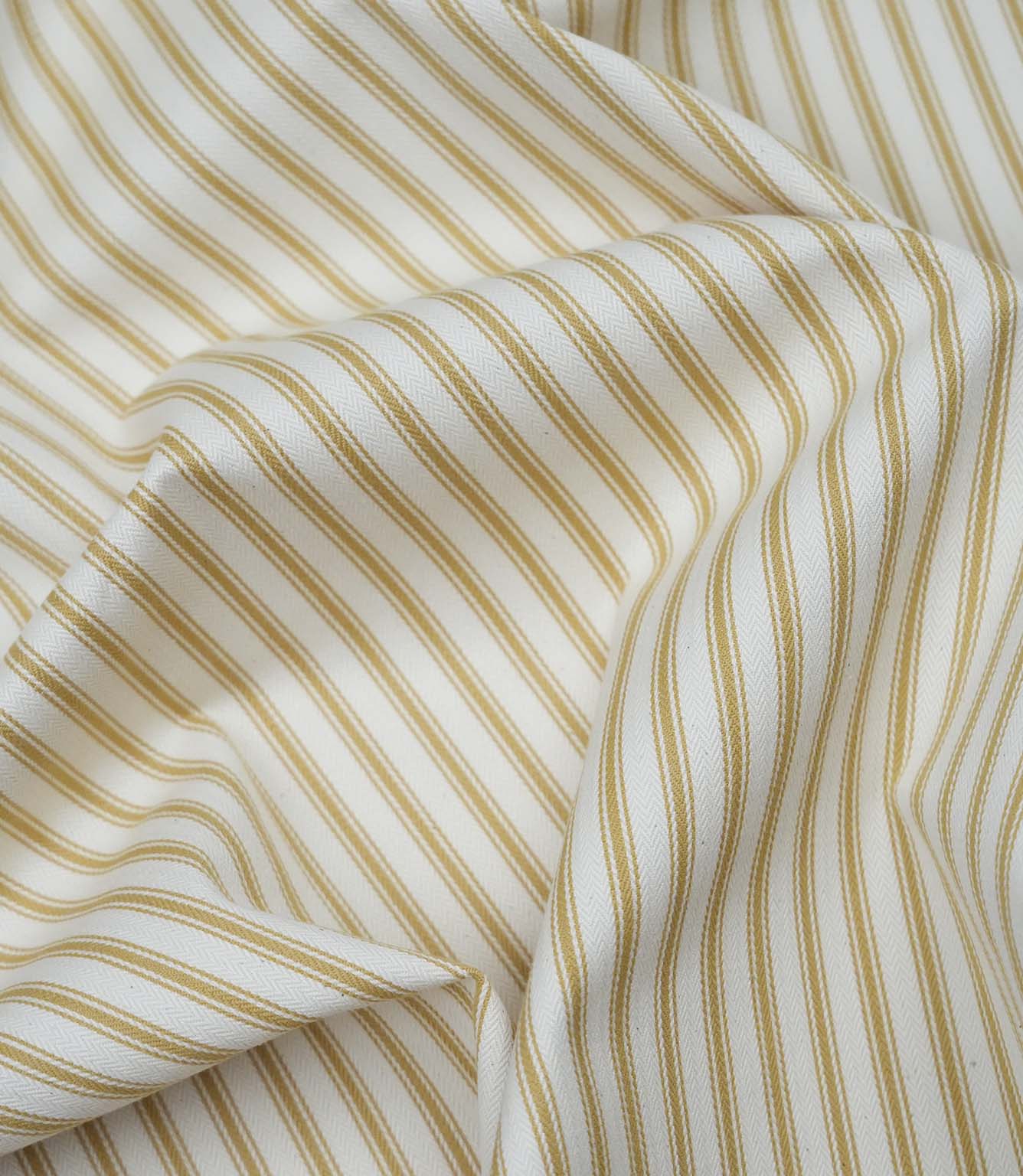 Ochre ticking stripe fabric draped to show its soft handle, elegant stripe pattern and woven herringbone texture.