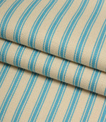 Folded ivory and Pacific blue striped ticking fabric highlighting the woven herringbone texture and soft drape.