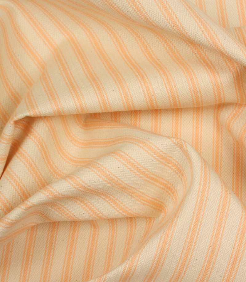 Draped peach ticking stripe fabric highlighting elegant folds and the timeless woven stripe pattern.