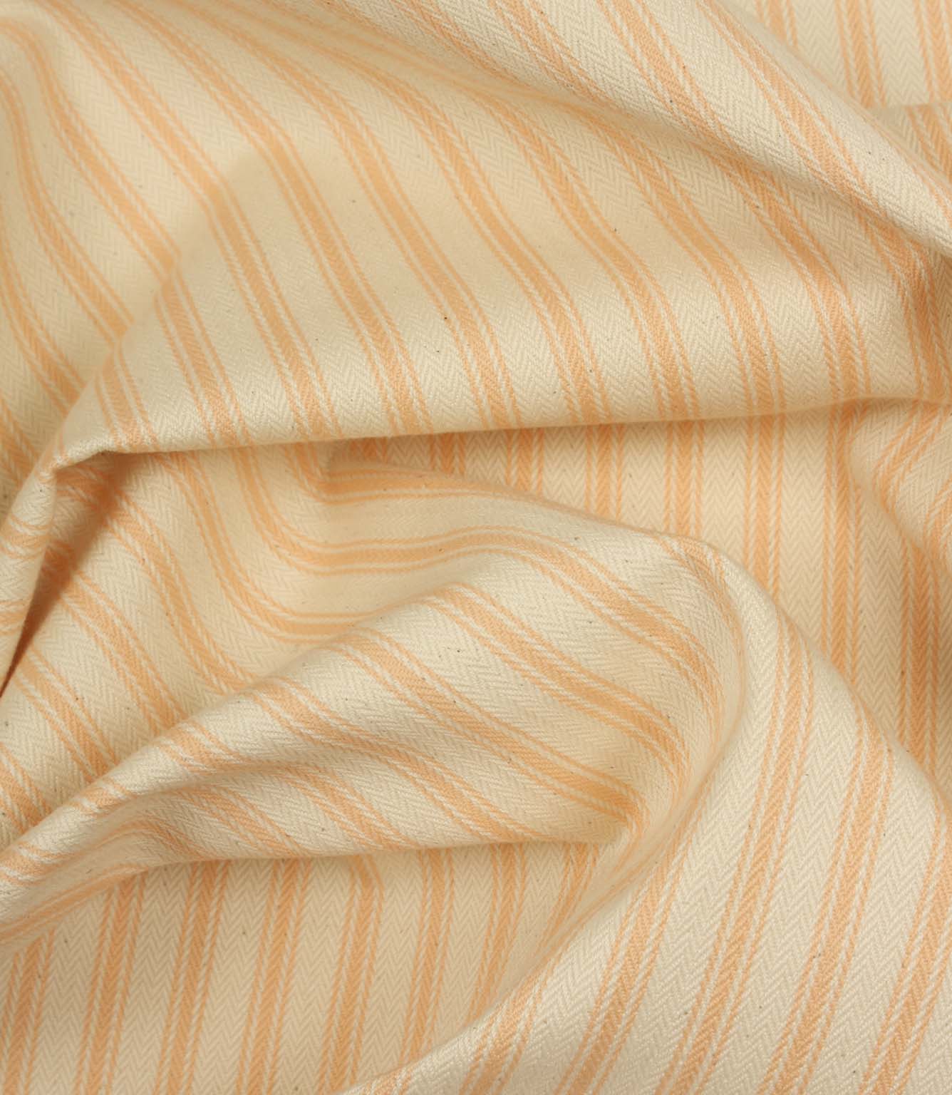 Draped peach ticking stripe fabric highlighting elegant folds and the timeless woven stripe pattern.