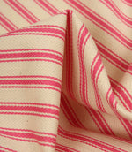 Detailed close-up of petunia pink striped ticking fabric with visible herringbone weave and soft fabric folds.