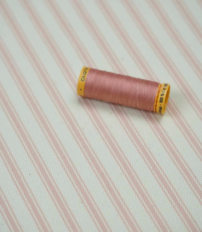 Pink ticking stripe fabric with matching pink thread, ideal for upholstery, curtains, blinds and sewing projects.