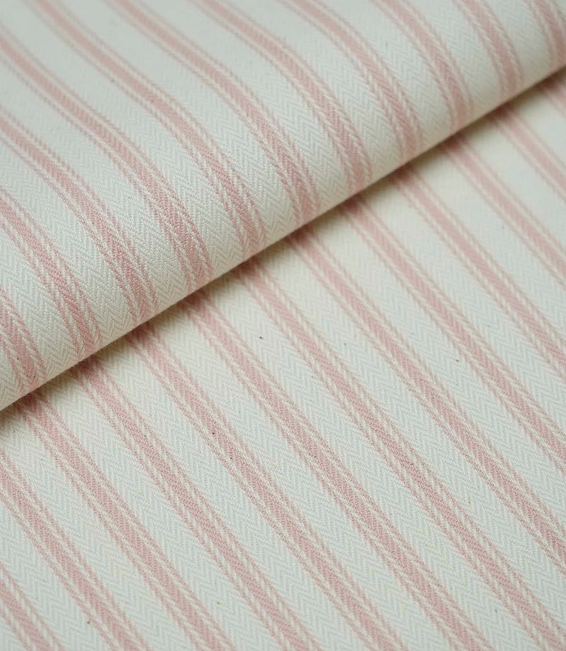 Folded pink ticking stripe fabric showcasing the timeless striped pattern and premium woven herringbone finish.