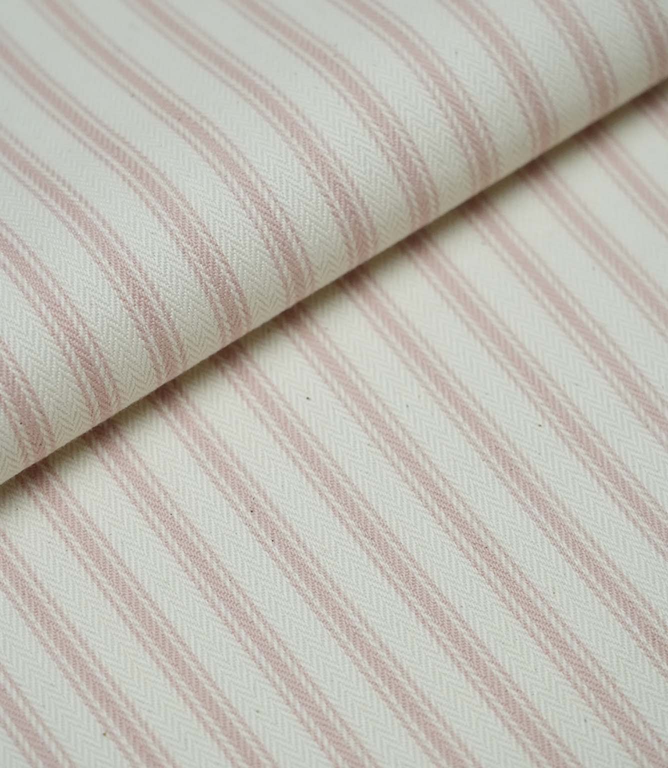 Folded pink ticking stripe fabric showcasing the timeless striped pattern and premium woven herringbone finish.