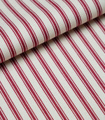 Folded red ticking stripe fabric showcasing the timeless striped pattern and premium woven herringbone finish.