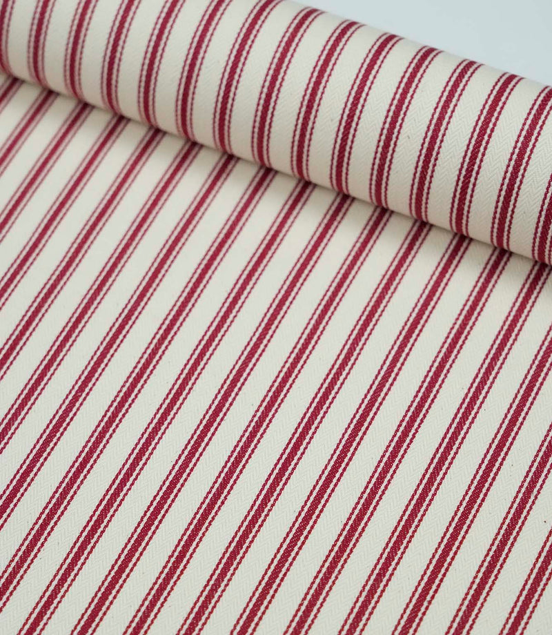 Rolled red ticking stripe fabric highlighting the classic striped design and subtle woven herringbone texture.