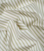 Sage green ticking stripe fabric draped to show its soft handle, elegant stripe pattern and woven herringbone texture.