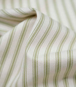 Close-up detail of sage green ticking stripe fabric showing the fine woven texture and soft sage green stripe pattern.