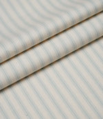 Layered folds of Sea Spray blue ticking stripe fabric showcasing the fine woven herringbone texture and elegant stripes.