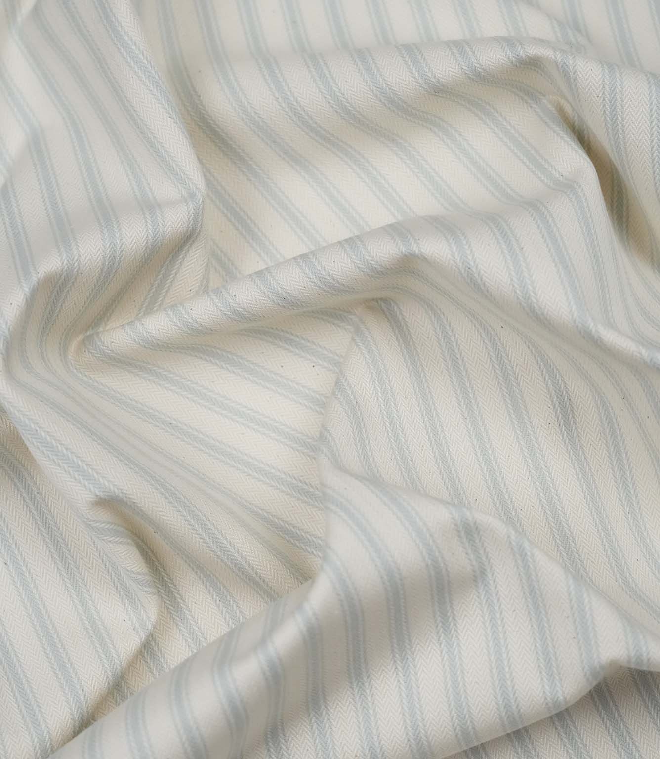 Sea Spray ticking stripe fabric draped to display its soft handle, subtle herringbone weave and timeless striped pattern.