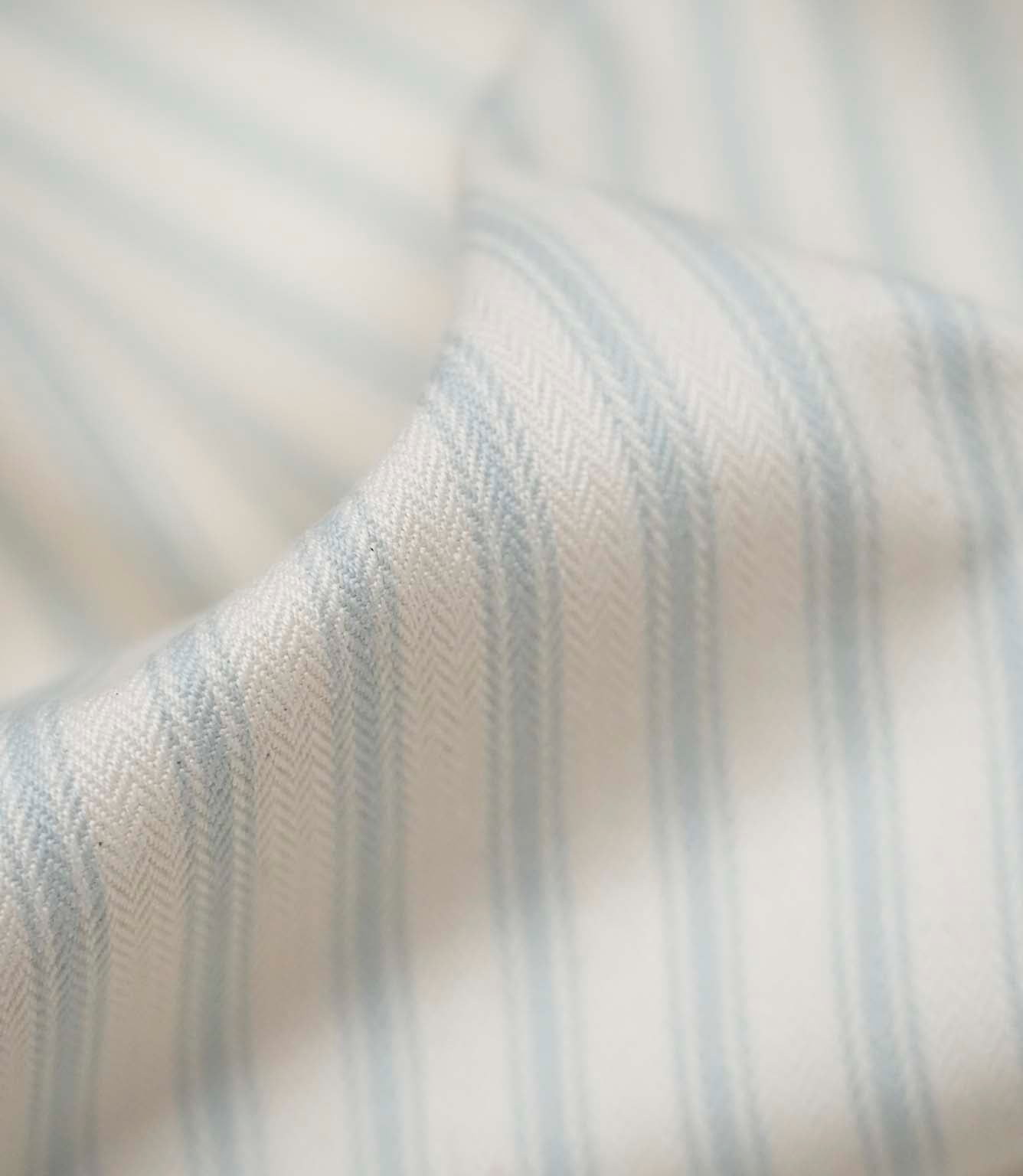 Close-up of Sea Spray ticking stripe fabric highlighting the woven texture, soft finish and delicate blue stripes.