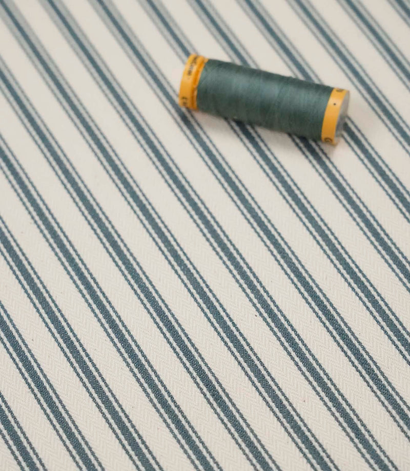 Teal ticking stripe fabric with matching teal thread, ideal for upholstery, curtains, blinds and sewing projects.