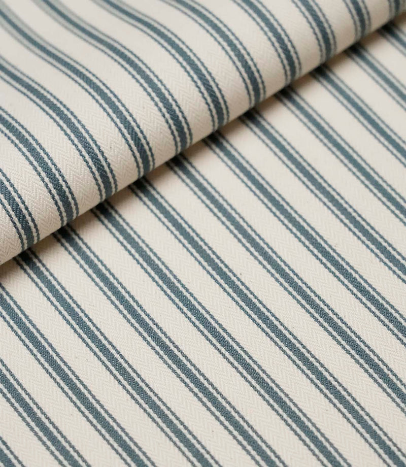 Folded teal ticking stripe fabric showcasing the timeless striped pattern and premium woven herringbone finish.