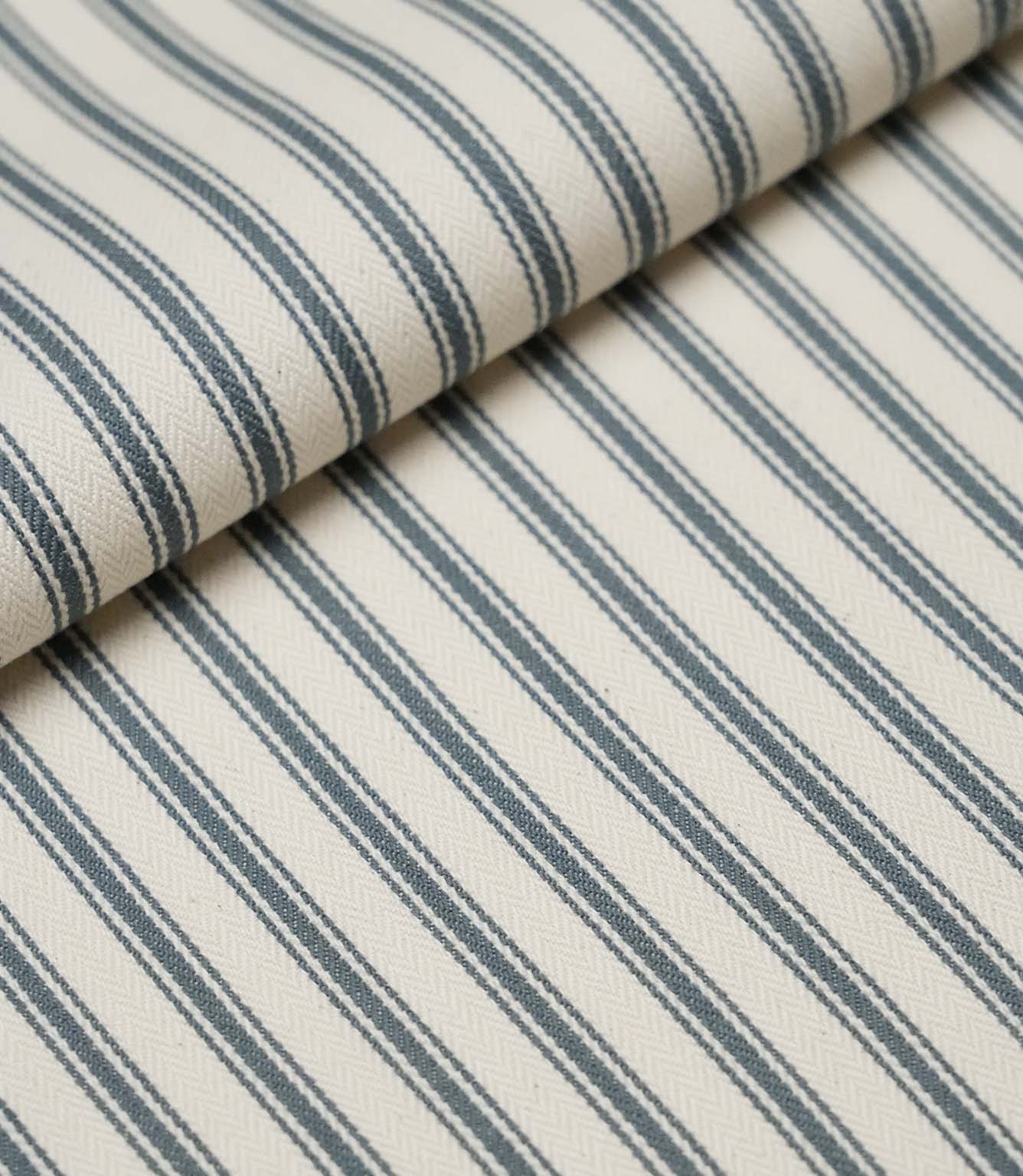 Folded teal ticking stripe fabric showcasing the timeless striped pattern and premium woven herringbone finish.