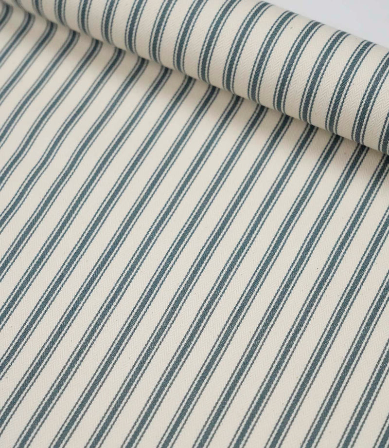 Rolled teal ticking stripe fabric highlighting the classic striped design and subtle woven herringbone texture.