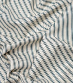 Teal ticking stripe fabric draped to show its soft handle, elegant stripe pattern and woven herringbone texture.