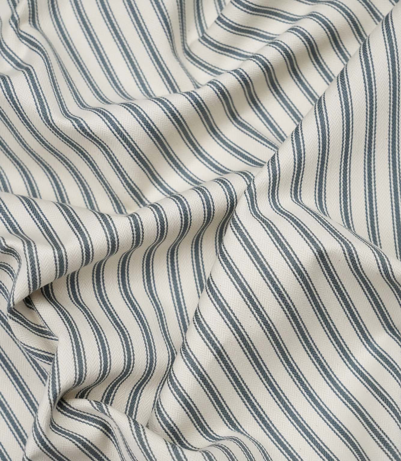 Teal ticking stripe fabric draped to show its soft handle, elegant stripe pattern and woven herringbone texture.