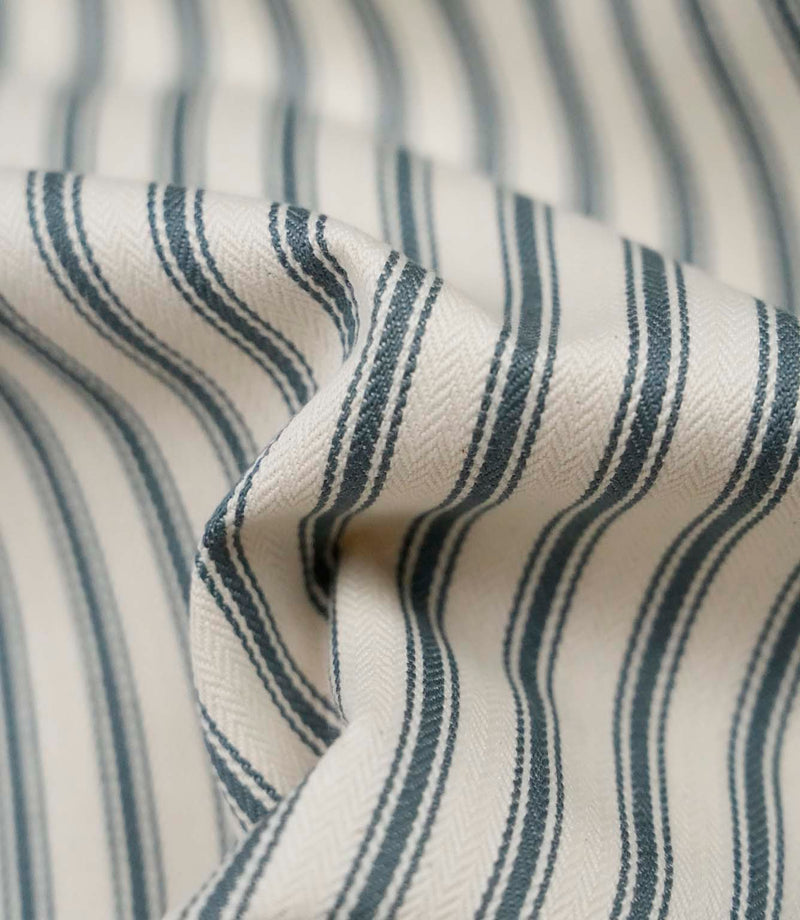 Close-up detail of teal ticking stripe fabric showing the fine woven herringbone texture and classic teal ticking stripes.