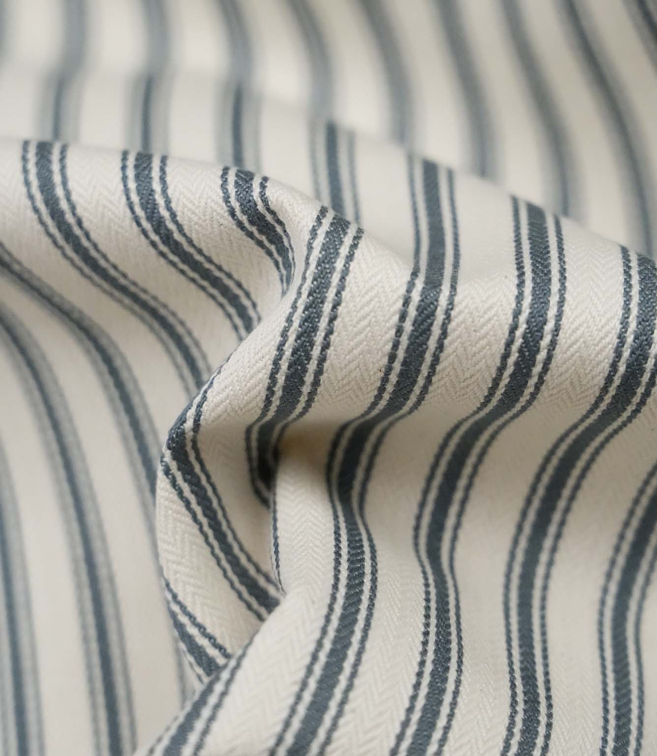 Close-up detail of teal ticking stripe fabric showing the fine woven herringbone texture and classic teal ticking stripes.