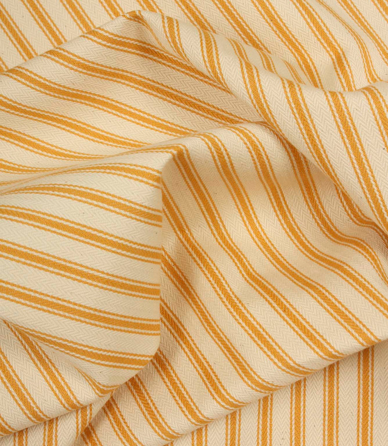 Gathered turmeric yellow ticking stripe fabric showing natural folds and durable woven finish.
