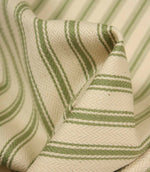 Detailed close-up of warm green striped ticking fabric with visible herringbone weave and elegant fabric drape.