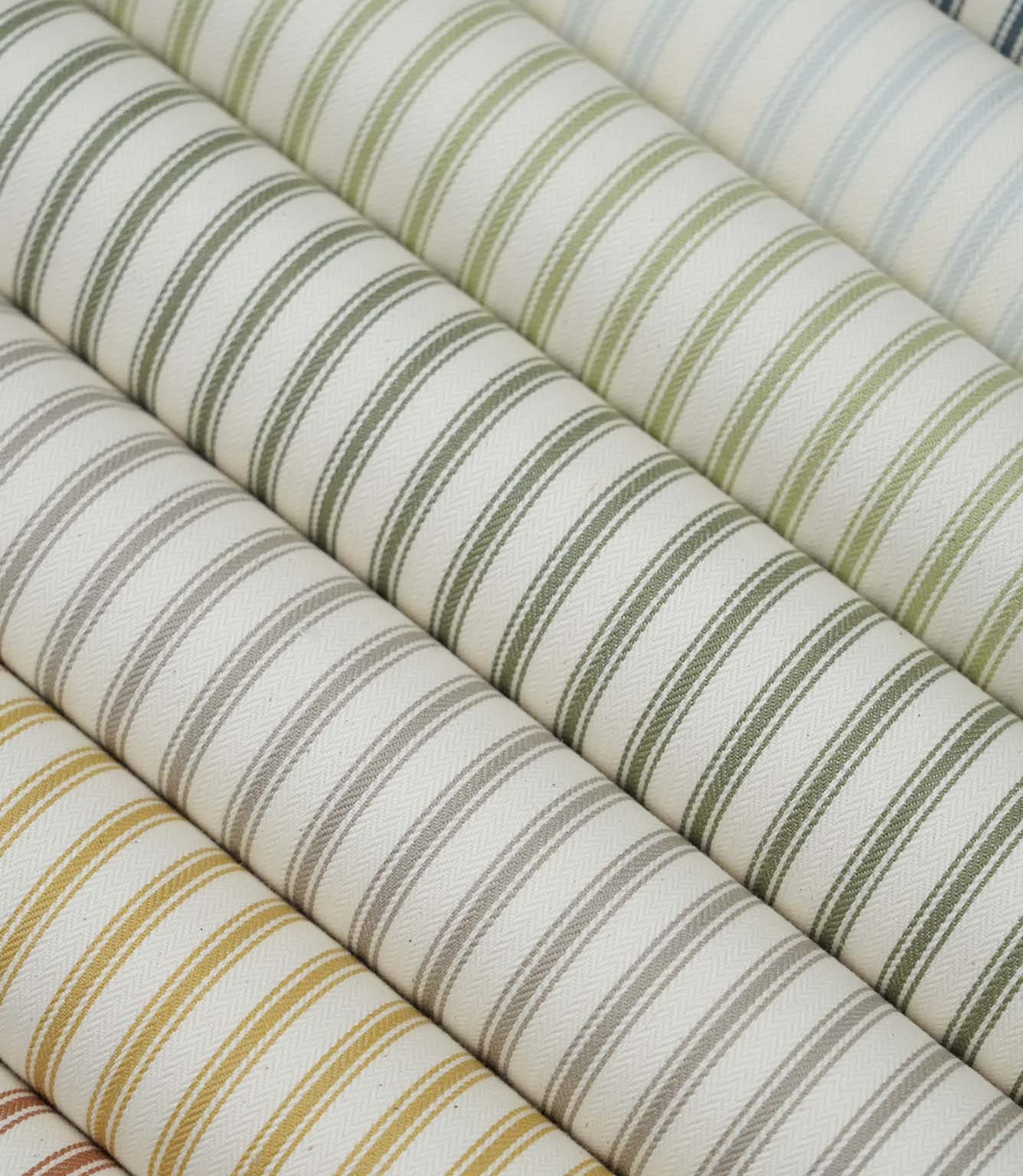 Collection of ticking stripe fabrics in sage green, duck egg blue, taupe, mustard and terracotta colourways, each featuring a classic striped design on an ivory herringbone weave.