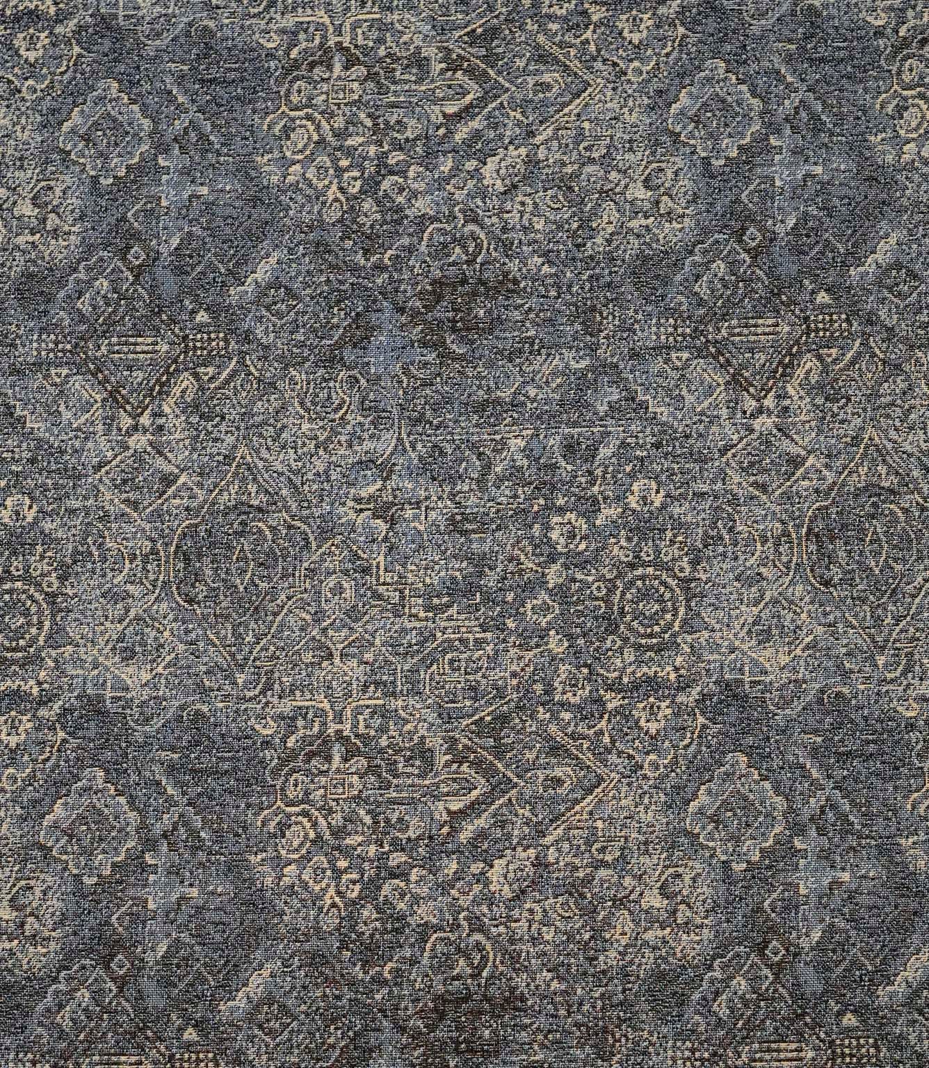 Blue Keshan tapestry upholstery fabric with an intricate distressed Persian-inspired pattern in soft blue, grey and beige tones.