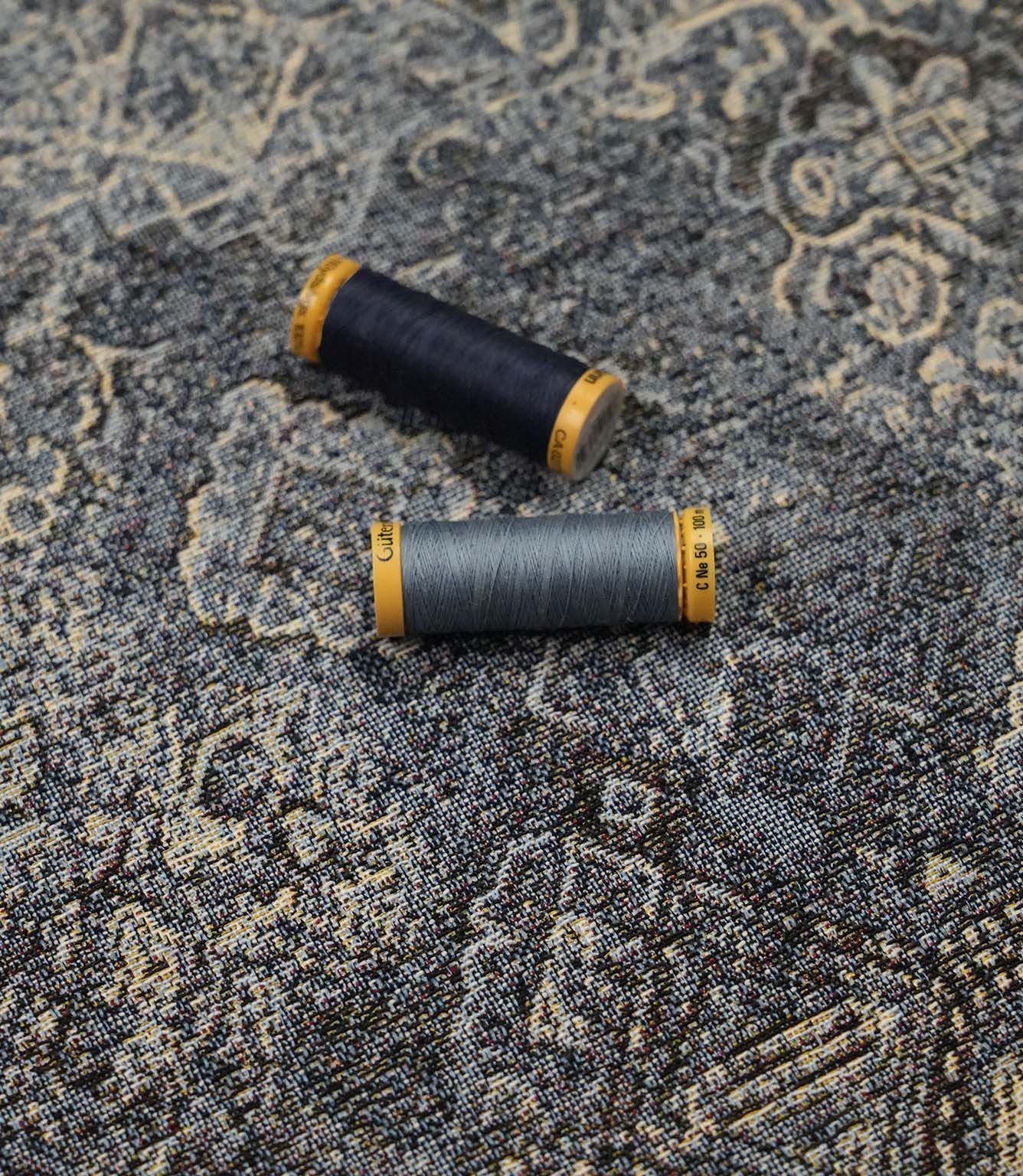 Blue Keshan tapestry fabric with coordinating blue sewing threads, suitable for upholstery, cushions and soft furnishing projects.