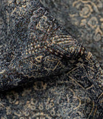 Close-up of blue Keshan tapestry upholstery fabric showing the detailed woven texture and distressed Persian-style motif.