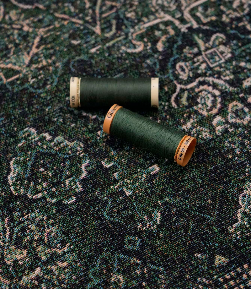 Green Keshan tapestry fabric with coordinating green sewing threads, ideal for upholstery, curtains and soft furnishing projects.