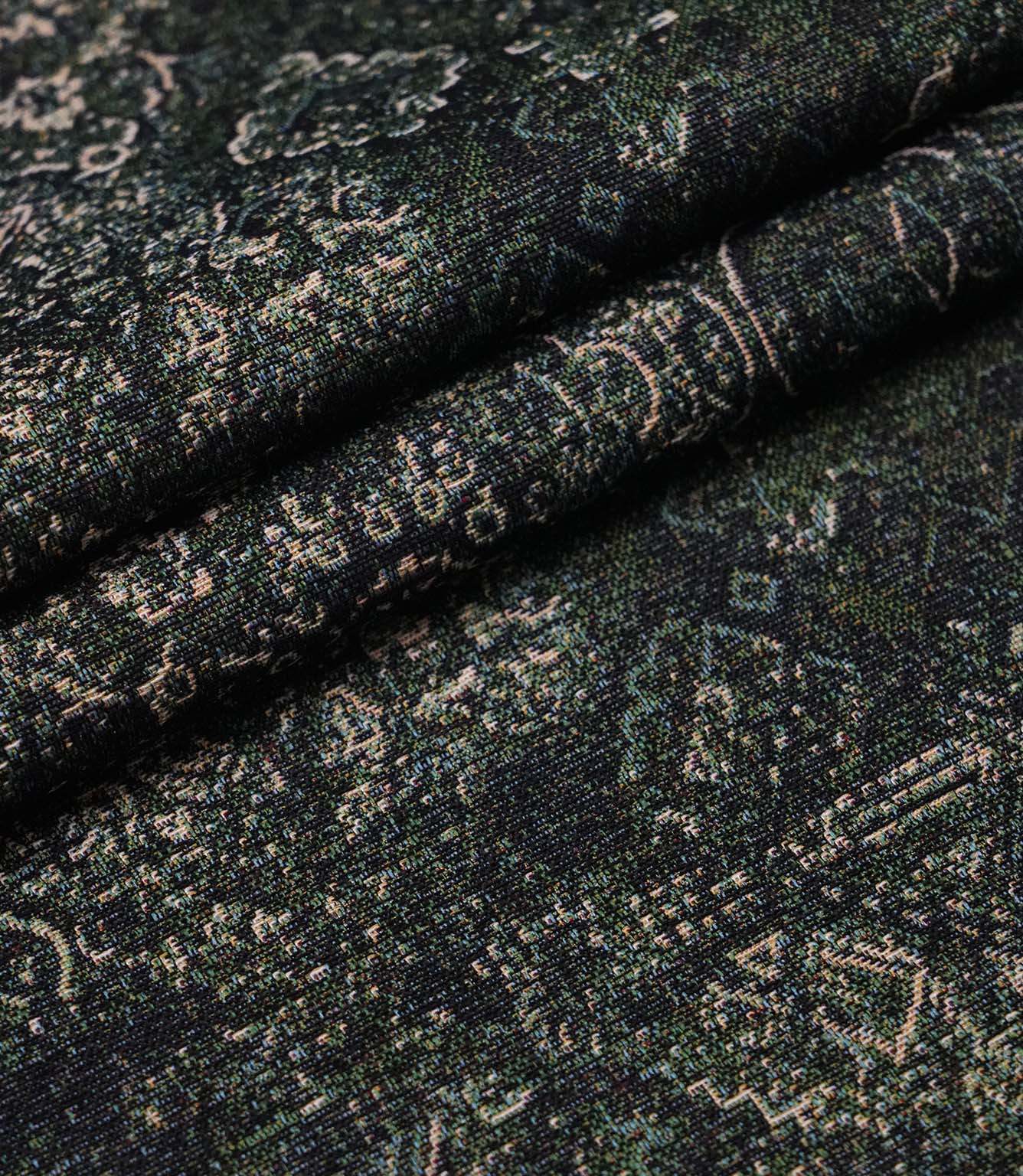 Folded green Keshan tapestry upholstery fabric showcasing the detailed woven texture and vintage Persian-inspired design.