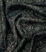 Green Keshan tapestry fabric draped to highlight its soft handle, woven texture and distressed Persian-style pattern.