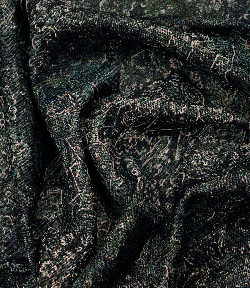 Green Keshan tapestry fabric draped to highlight its soft handle, woven texture and distressed Persian-style pattern.