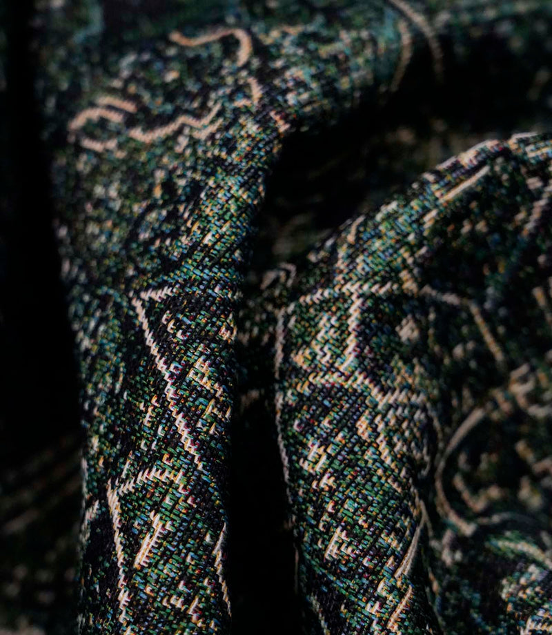 Close-up of green Keshan tapestry upholstery fabric showing the intricate woven texture and antique-inspired Persian motif.