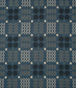 Kinfolk geometric fabric in warm terracotta orange with repeating black, grey and cream woven-style motifs.