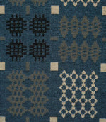 Close-up of Kinfolk fabric showing geometric black, grey and cream motifs against a terracotta orange ground.