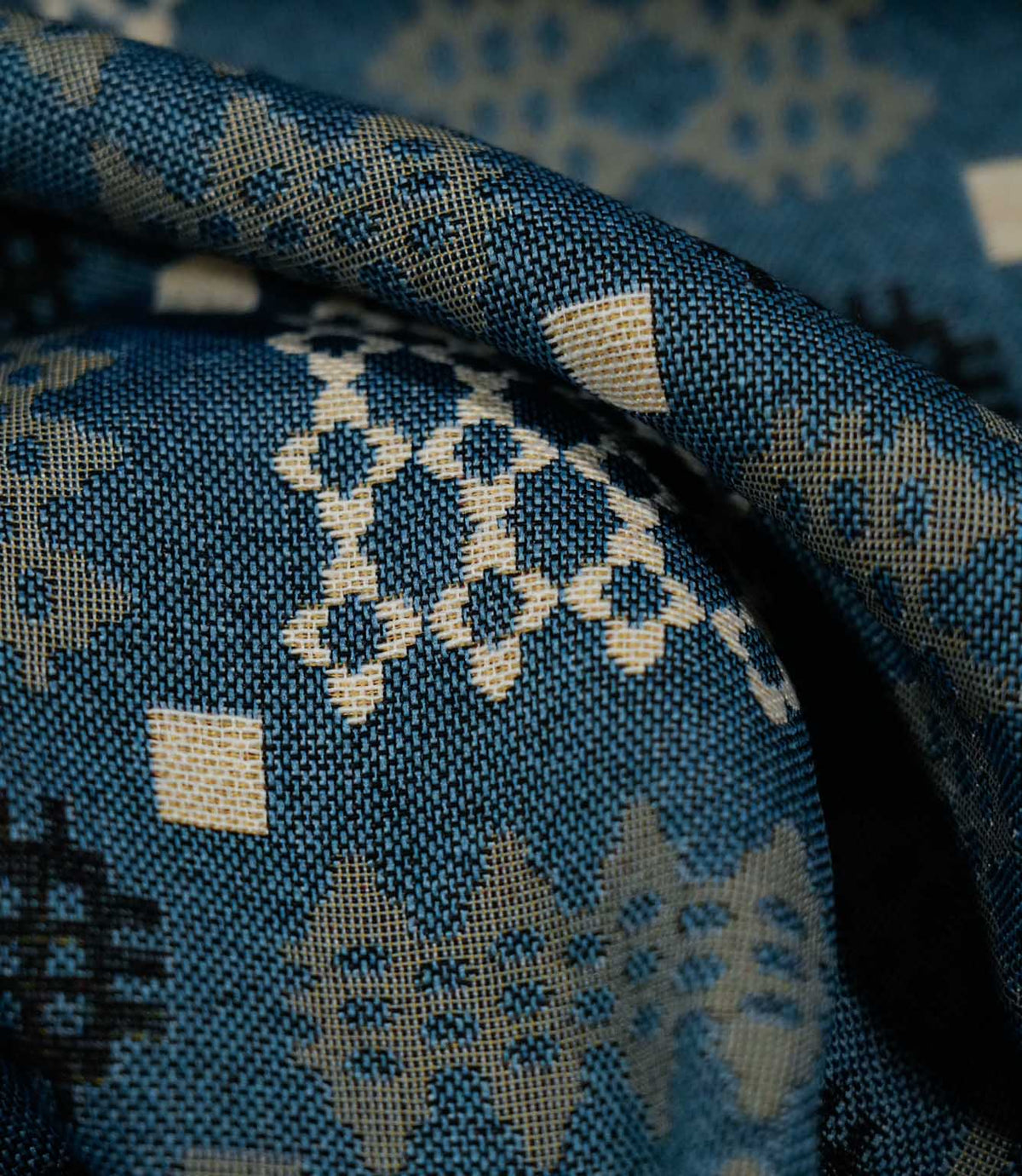 Detailed close-up of Kinfolk fabric showing its textured weave and black geometric motif on a terracotta orange ground.