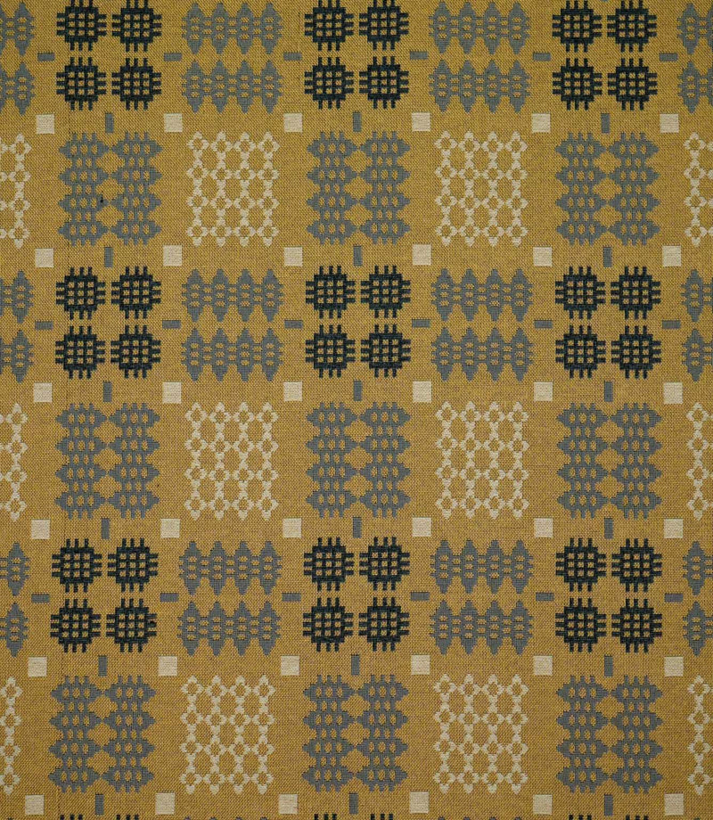 Kinfolk geometric fabric shown flat, with a mustard yellow ground and repeating charcoal, grey and cream woven motifs arranged in a structured pattern.