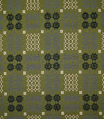 Kinfolk geometric fabric shown flat, with an olive green ground and repeating black, grey and cream woven-style motifs arranged in a structured pattern.