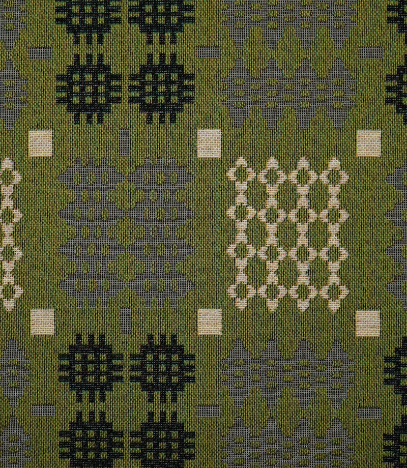 Close-up of Kinfolk fabric showing its textured weave and Scandi-inspired geometric pattern in black, soft grey and cream against an olive green background.