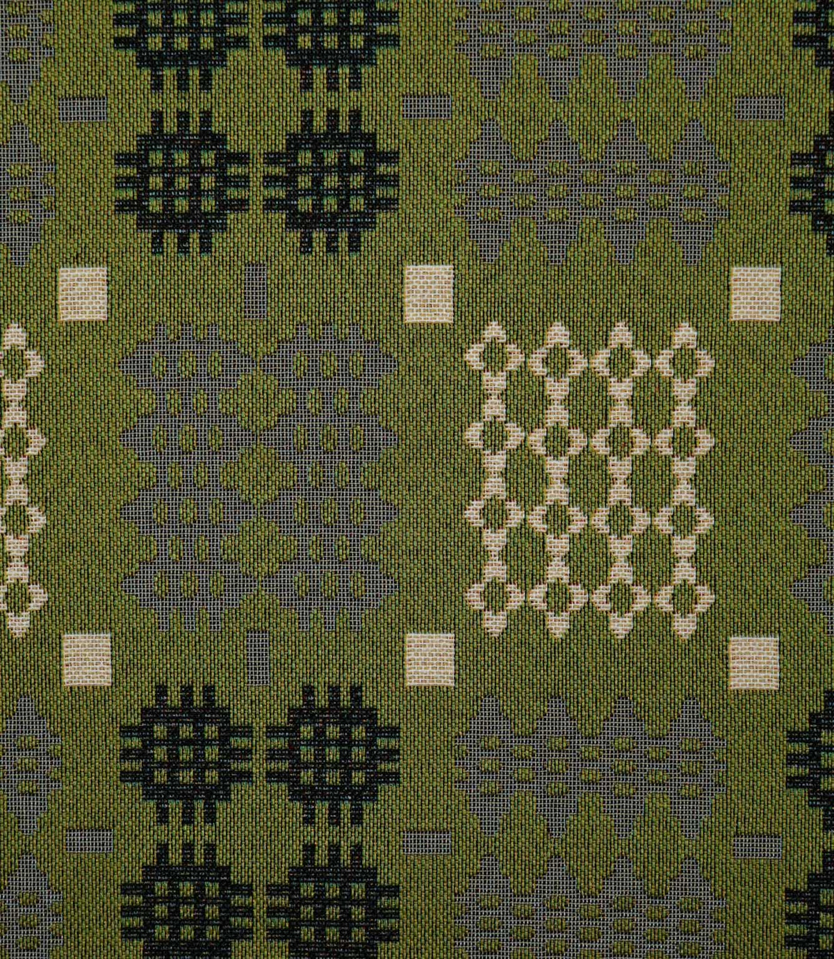 Close-up of Kinfolk fabric showing its textured weave and Scandi-inspired geometric pattern in black, soft grey and cream against an olive green background.