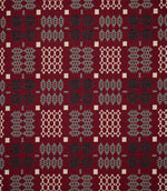 Kinfolk geometric fabric shown flat, featuring a rich red ground with repeating black, soft grey and cream woven-style motifs in a structured pattern.