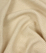 Close-up of beige fabric with a herringbone pattern